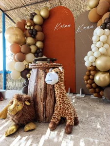 Safari themed birthday decoration with earth tone balloons and plush animals