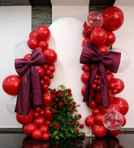 Red balloon columns with burgundy bows for a birthday party
