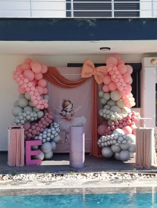 Poolside girl's birthday with pink balloons and peach bow