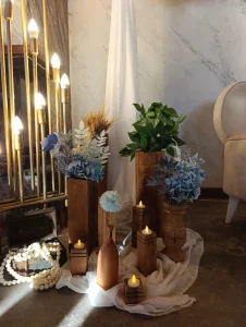 Candles, blue flowers and white drapes for an engagement setup