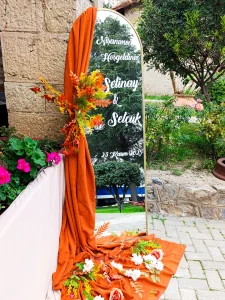 Engagement welcome sign with orange drape in a garden