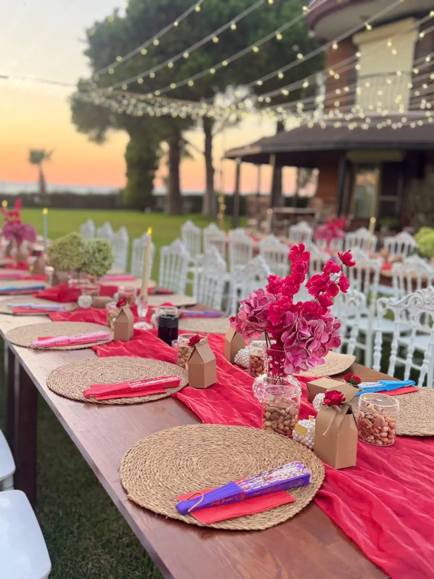 Long outdoor table with pink napkins and white chairs for a celebration in Kusadasi