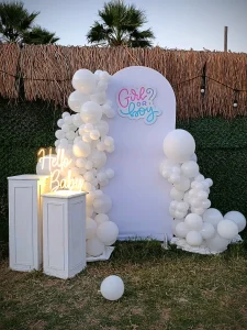 White balloon backdrop with pedestals for a baby shower or party setup