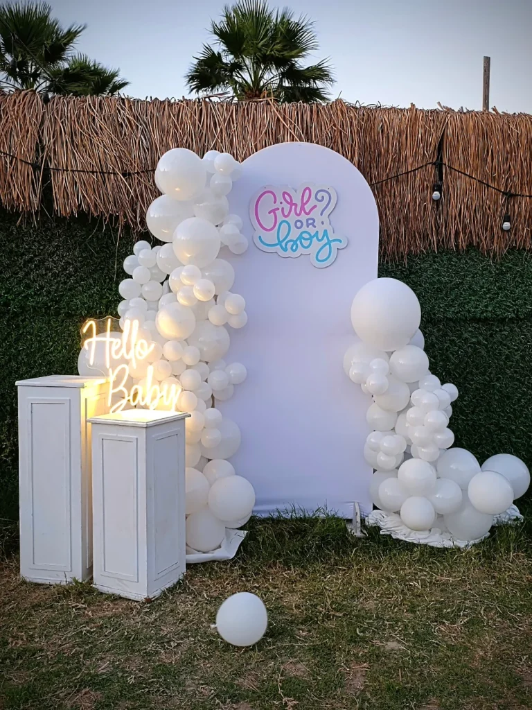 White balloon backdrop with pedestals for a baby shower or party setup