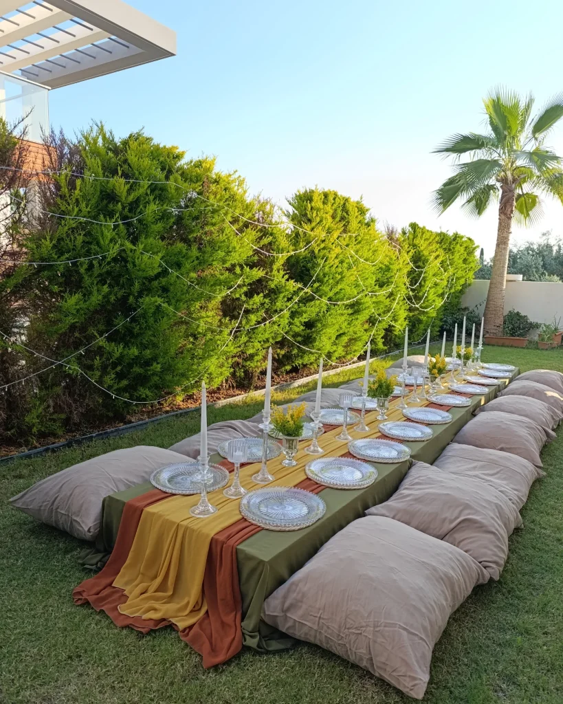 Low picnic table with cushions under trees for a garden celebration