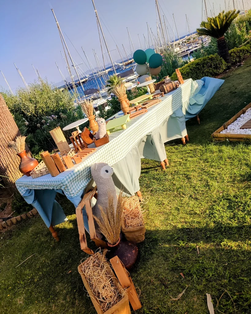 Long boho dining table with white linen and wicker lamps for a party in Kusadasi