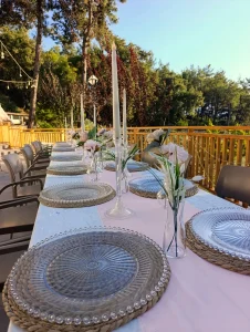 Long garden dinner table with glass chargers and candles