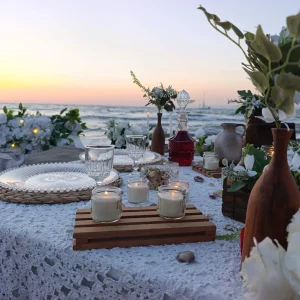 Seaside dinner table with candles at sunset