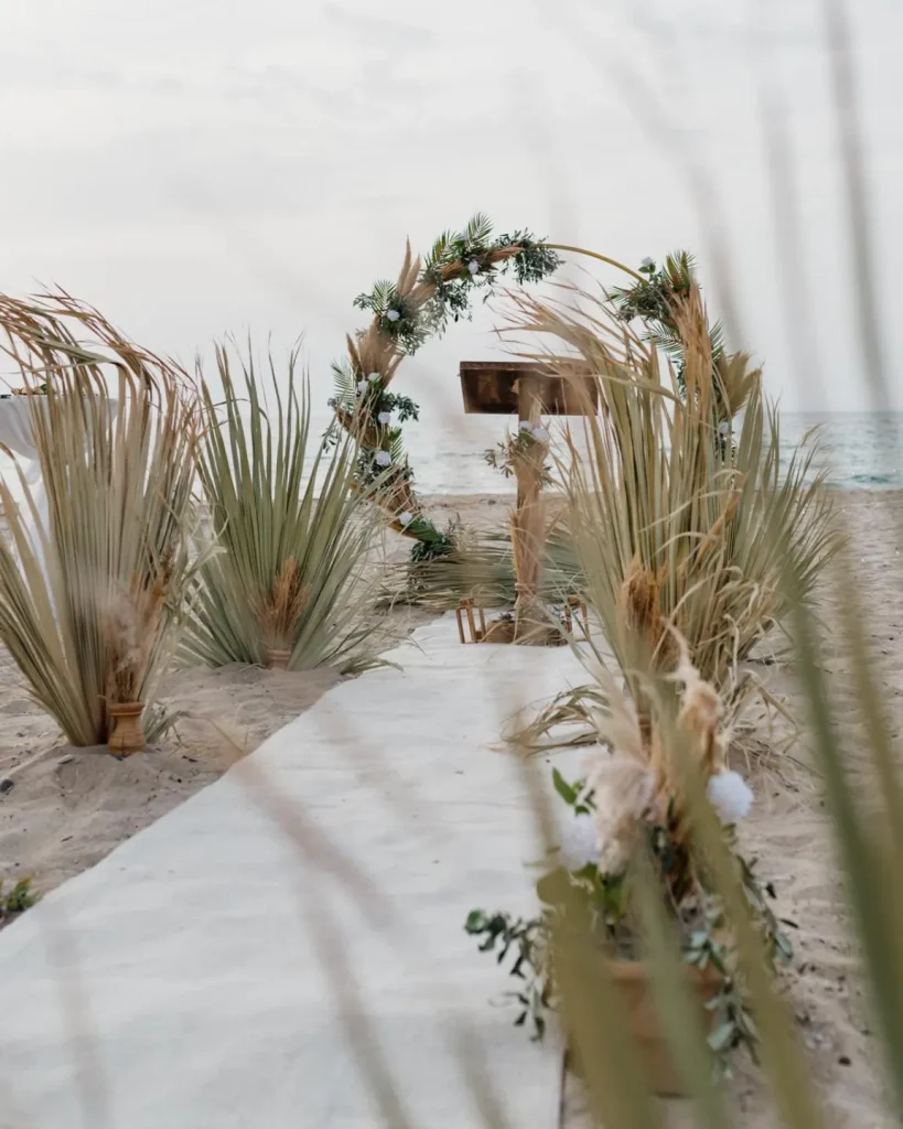 Boho beach wedding aisle with pampas grass and floral arch in Turkey