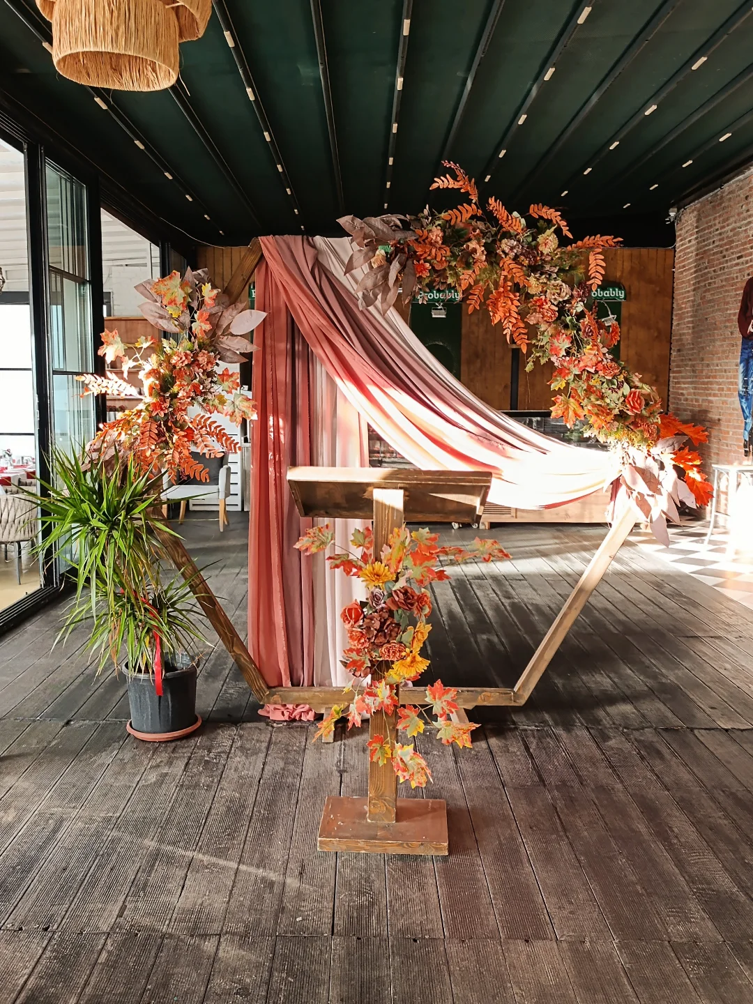 Wedding in Kusadasi ceremony arch with terracotta flowers and draped fabric on a wooden terrace