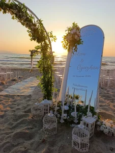 Beach wedding arch with welcome sign at sunset in Kusadasi