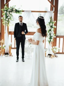 Engagement party in Kusadasi couple in front of a floral wooden arch with white drapes